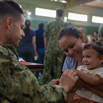 soldier giving child a flu shot.